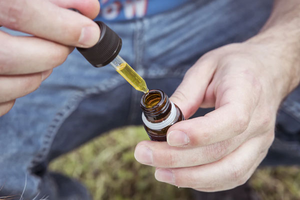 A man measures out his pet’s high-quality CBD Oil.