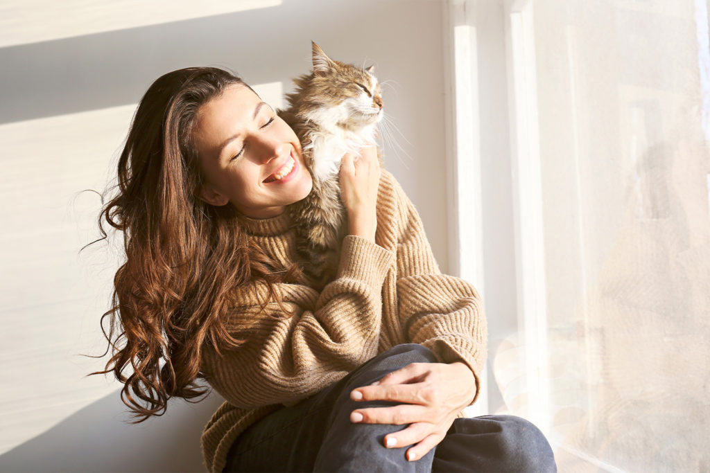 woman smiling holding cat