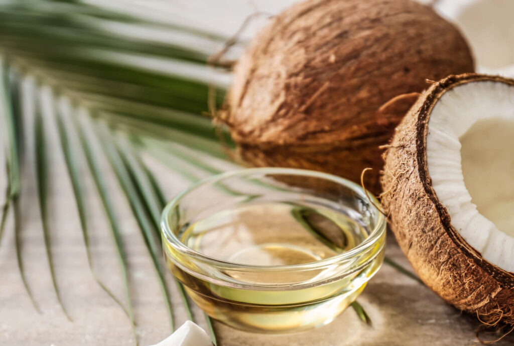 coconut oil in small glass bowl next to a coconut